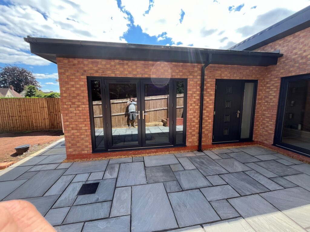 Single story house extension with double doors and external paving
